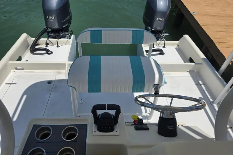 Slide: The Image of 2014 Custom Exuma Catamaran 32 cockpit with dual Yamaha 150 engines and striped seating. - 37