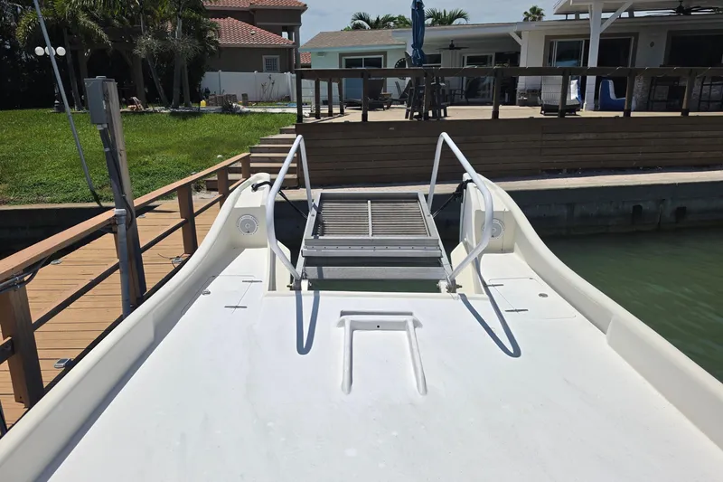 Slide: The Image of Custom Exuma Catamaran 32 (2014) docked near a waterfront home with lush greenery. - 25