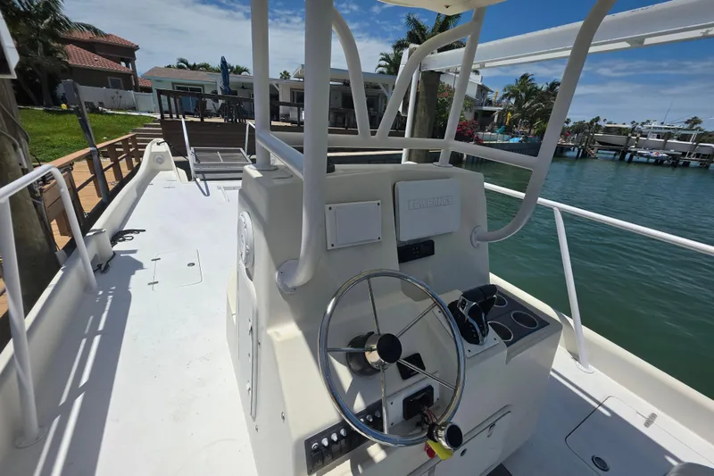 Slide: The Image of 2014 Custom Exuma Catamaran 32 with steering wheel, docked by waterfront homes. - 15