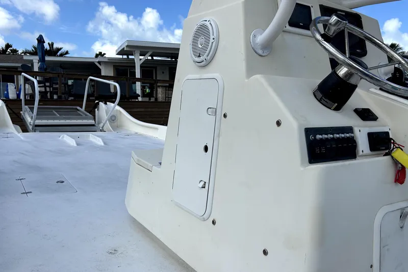 Slide: The Image of 2014 Custom Exuma Catamaran 32 with steering console, docked under blue sky. - 24