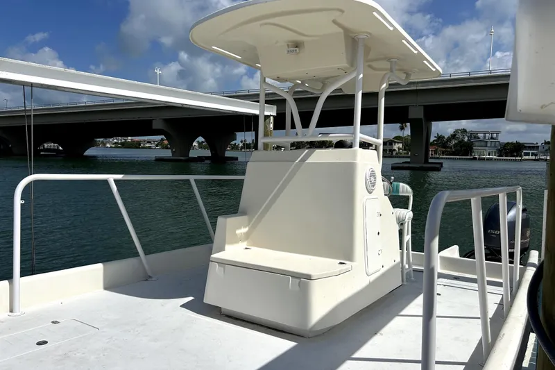 Slide: The Image of 2014 Custom Exuma Catamaran 32 on water near a bridge, showcasing helm and seating area. - 35