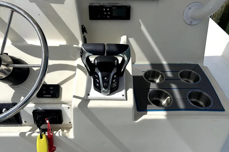 Slide: The Image of Cockpit controls of 2014 Custom Exuma Catamaran 32 with steering wheel and cup holders. - 19