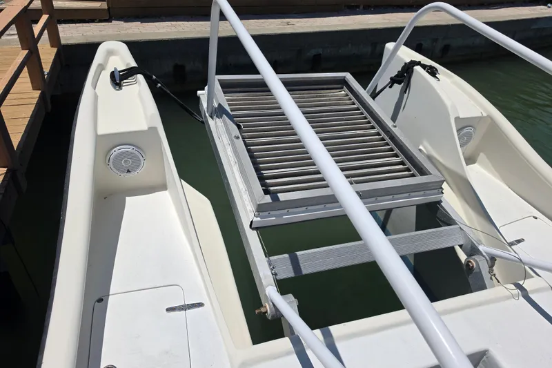 Slide: The Image of 2014 Custom Exuma Catamaran 32 docked, featuring a metal grate and white railing. - 28