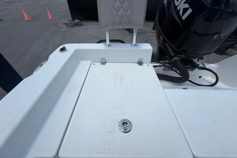 Slide: The Image of 2025 Savannah 210X boat deck with Suzuki outboard motor, featuring a cushioned seat. - 51