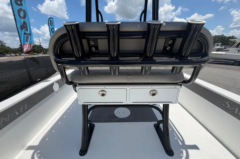 Slide: The Image of 2025 Savannah 210X boat interior with rod holders and storage drawers under a sunny sky. - 12