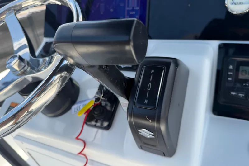 Slide: The Image of Close-up of 2025 Savannah 210X boat controls, featuring steering wheel and throttle lever. - 24
