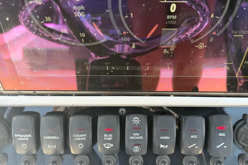 Slide: The Image of Dashboard of a 2025 Savannah 210X boat with various control switches and gauges. - 21
