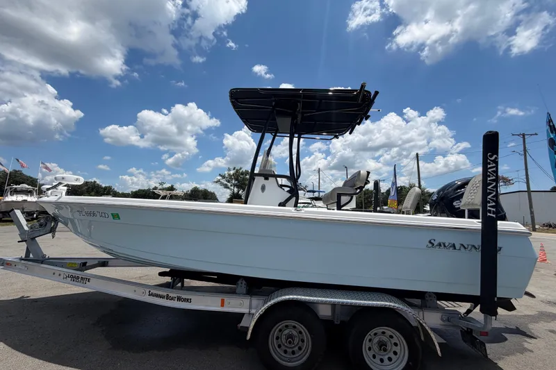 Slide: The Image of 2025 Savannah 210X boat on trailer under a partly cloudy sky. - 6