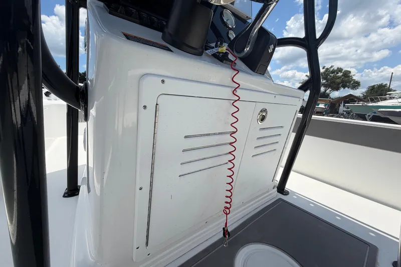 Slide: The Image of 2025 Savannah 210X boat console with safety lanyard, under a partly cloudy sky. - 25