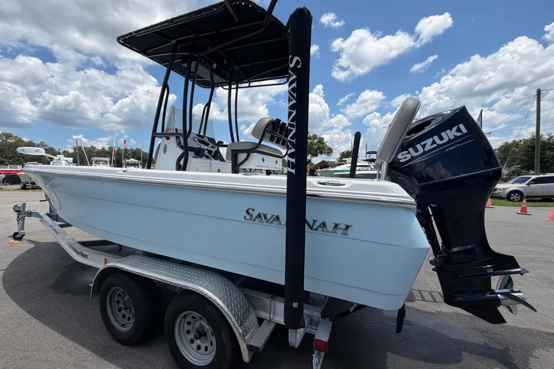 The Image of 2025 Savannah 210X boat with Suzuki engine on trailer under blue sky. - 0