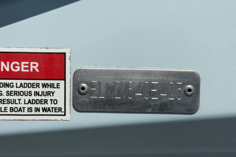 Slide: The Image of Hull identification number on a 2025 Savannah 210X boat with safety warning label. - 59
