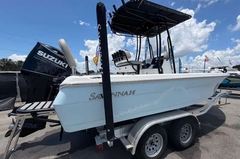 Slide: The Image of 2025 Savannah 210X boat on trailer with Suzuki outboard motor, under clear blue sky. - 3