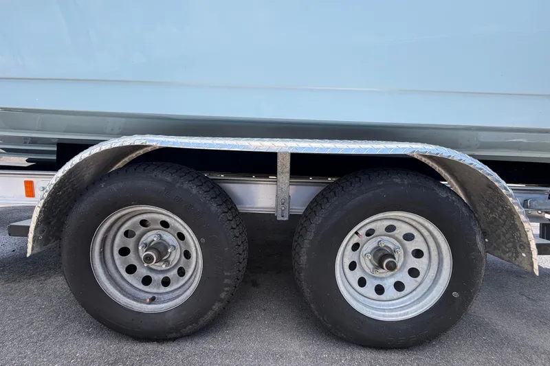 Slide: The Image of Trailer wheels of a 2025 Savannah 210X boat on pavement. - 62