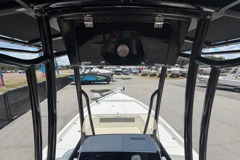 Slide: The Image of 2025 Savannah 210X boat interior view with navigation equipment and marina background. - 17