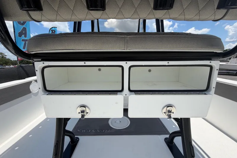 Slide: The Image of Storage compartments on a 2025 Savannah 210X boat, featuring cushioned seating and rod holders. - 13