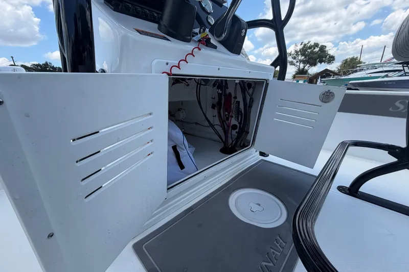 Slide: The Image of Open storage compartment on a 2025 Savannah 210X boat, showcasing interior wiring. - 26