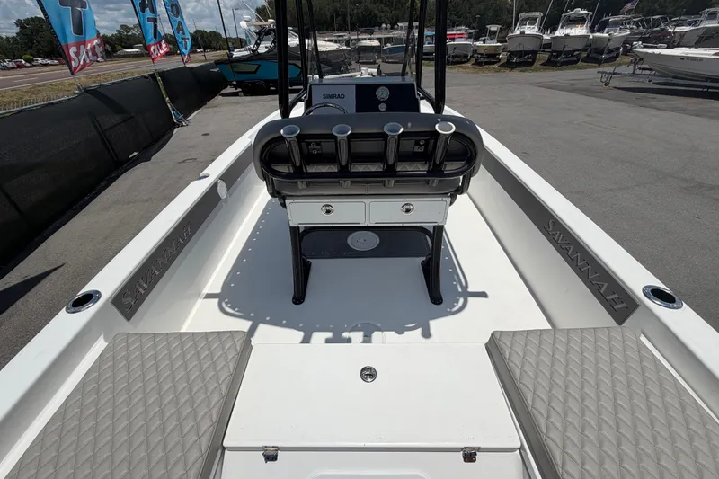 Slide: The Image of 2025 Savannah 210X boat interior with seating and console, displayed at a boat sale event. - 10