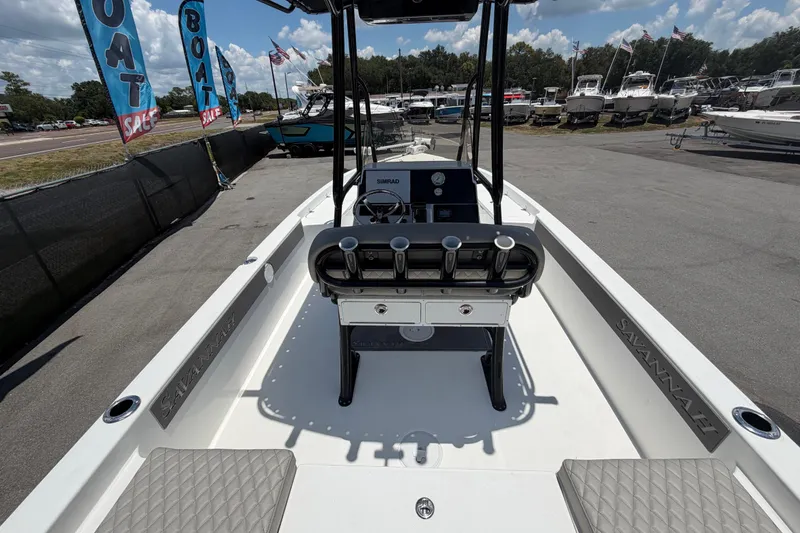 Slide: The Image of 2025 Savannah 210X boat on display at a dealership, featuring modern design and equipment. - 11