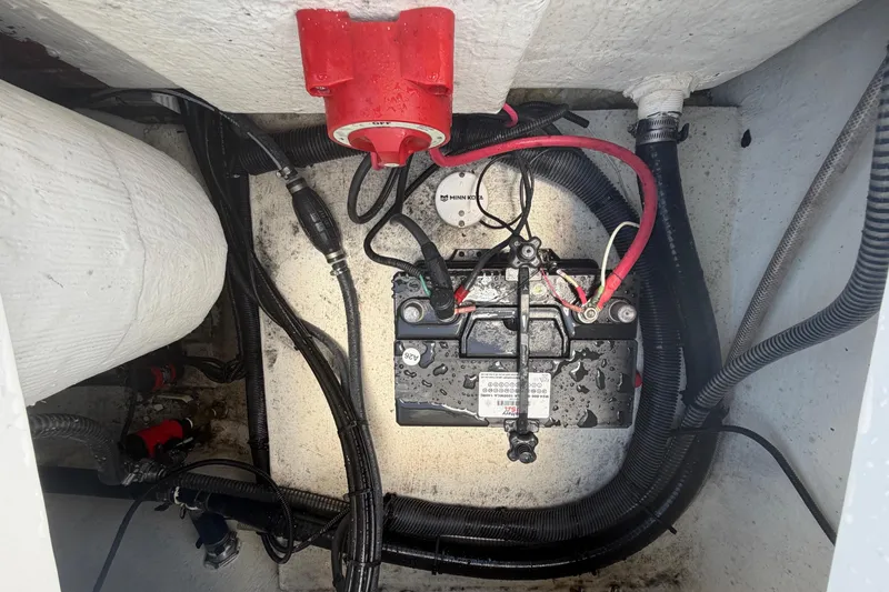 Slide: The Image of Battery compartment of 2025 Savannah 210X boat with wiring and red switch. - 52