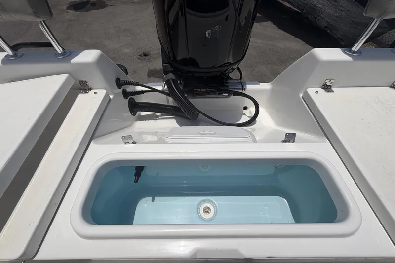 Slide: The Image of 2025 Savannah 210X boat with open storage compartment and visible engine. - 54