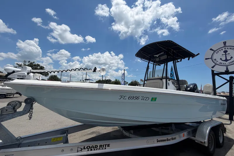 Slide: The Image of 2025 Savannah 210X boat on trailer under blue sky with clouds. - 7