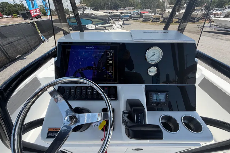 Slide: The Image of 2025 Savannah 210X boat dashboard with steering wheel, navigation display, and control panel. - 19
