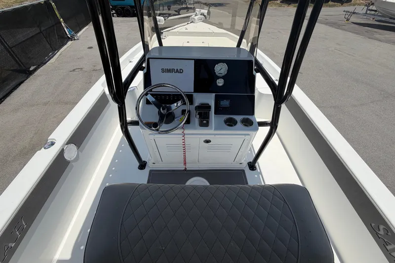 Slide: The Image of 2025 Savannah 210X boat console with Simrad electronics, steering wheel, and cup holders. - 15