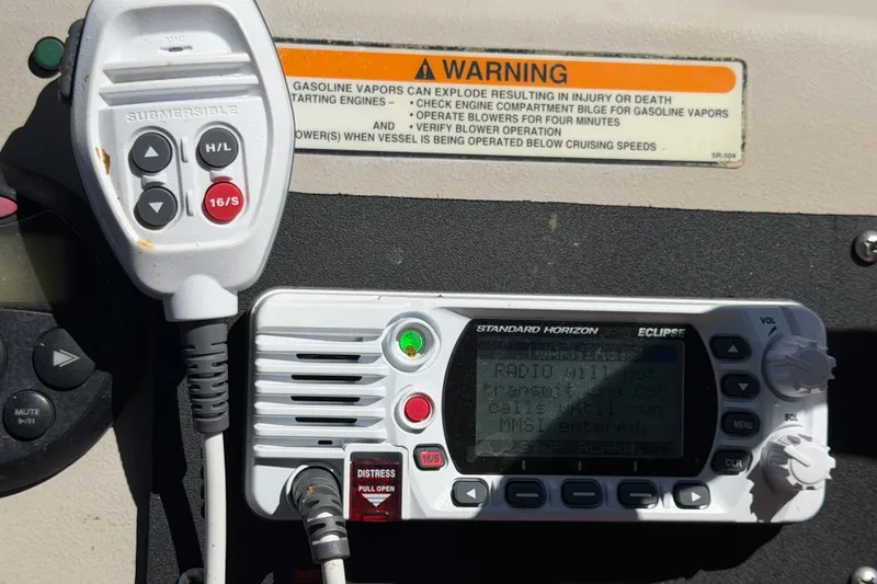 Slide: The Image of VHF radio and microphone on 2006 Sea Ray 300 Sundancer boat dashboard with safety warning. - 31