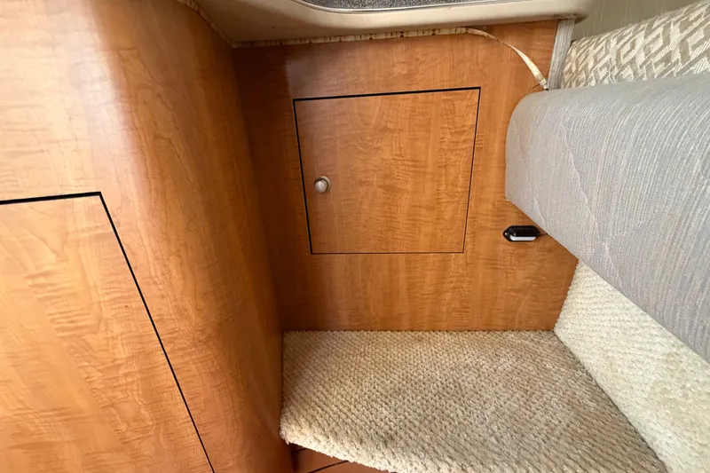 Slide: The Image of Interior cabin of 2006 Sea Ray 300 Sundancer with wood paneling and carpeted flooring. - 73