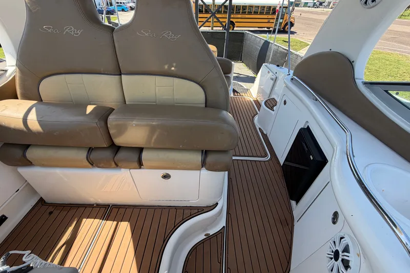 Slide: The Image of Interior of 2006 Sea Ray 300 Sundancer boat with tan seating and wood flooring. - 105