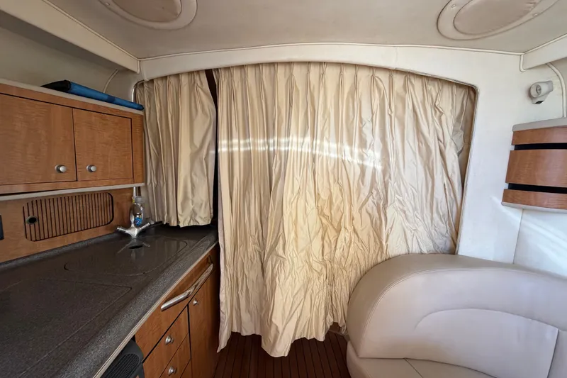 Slide: The Image of Interior of 2006 Sea Ray 300 Sundancer with kitchenette and beige curtain. - 76