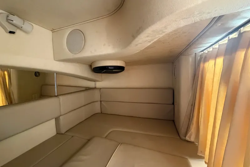 Slide: The Image of Interior cabin of 2006 Sea Ray 300 Sundancer with beige seating and curtains. - 99