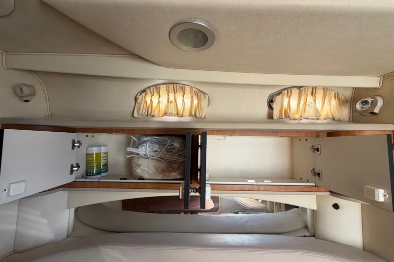 Slide: The Image of Interior of 2006 Sea Ray 300 Sundancer with open storage cabinets and curtains. - 88