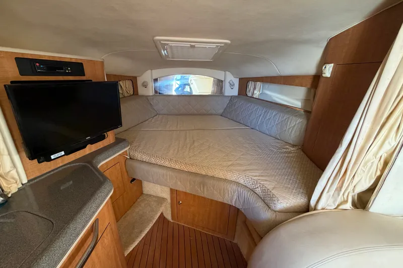 Slide: The Image of Interior cabin of 2006 Sea Ray 300 Sundancer with bed and TV setup. - 75