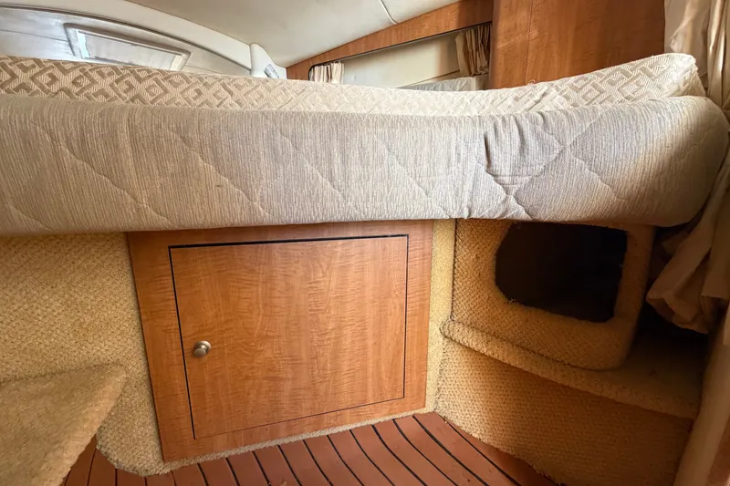 Slide: The Image of Interior cabin of 2006 Sea Ray 300 Sundancer with wooden storage and cushioned bed. - 77