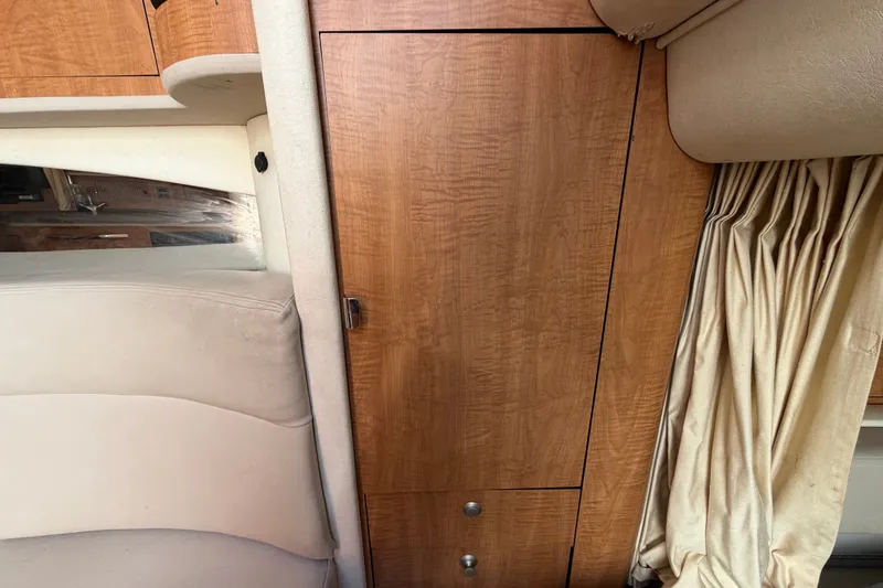 Slide: The Image of Interior of 2006 Sea Ray 300 Sundancer with wood paneling and beige upholstery. - 93