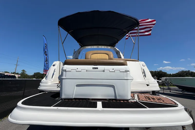 Slide: The Image of 2006 Sea Ray 300 Sundancer boat with American flag, docked under clear blue sky. - 3