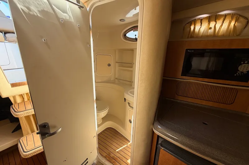 Slide: The Image of Interior of 2006 Sea Ray 300 Sundancer showing bathroom and kitchenette area. - 58