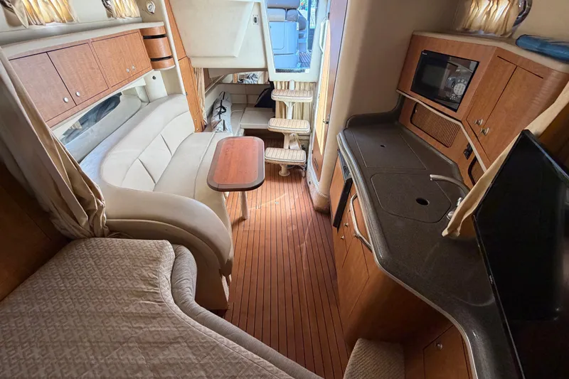 Slide: The Image of Interior of 2006 Sea Ray 300 Sundancer yacht with kitchenette and seating area. - 84