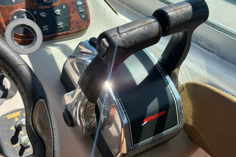 Slide: The Image of Throttle controls of a 2006 Sea Ray 300 Sundancer boat with Mercury branding. - 37