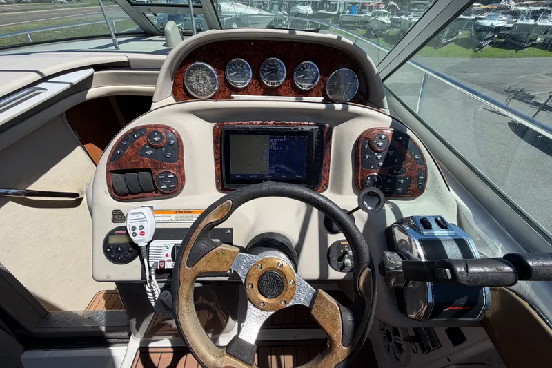 Slide: The Image of Helm of 2006 Sea Ray 300 Sundancer with navigation controls and steering wheel. - 29