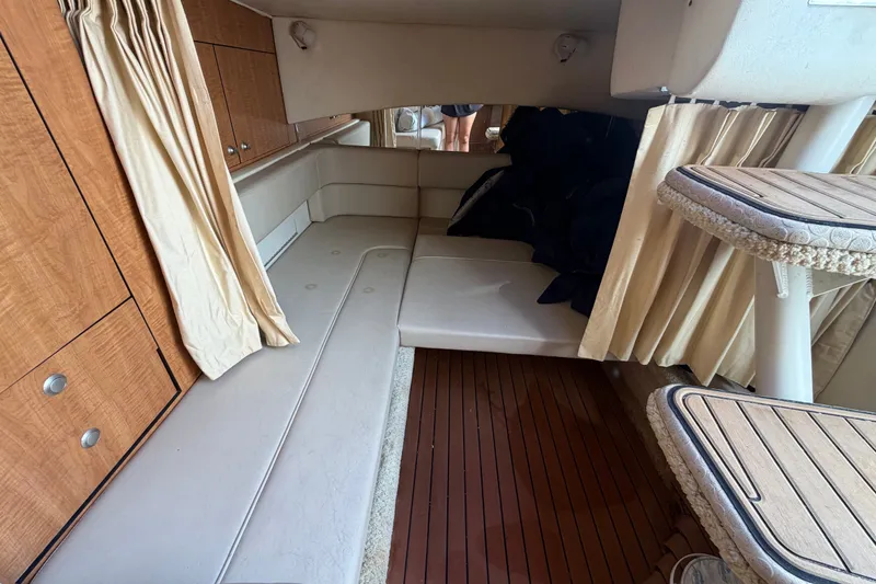 Slide: The Image of Interior cabin of 2006 Sea Ray 300 Sundancer with wood paneling and seating area. - 97