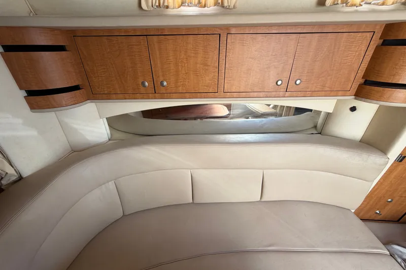 Slide: The Image of Interior of 2006 Sea Ray 300 Sundancer with beige seating and wooden cabinetry. - 87