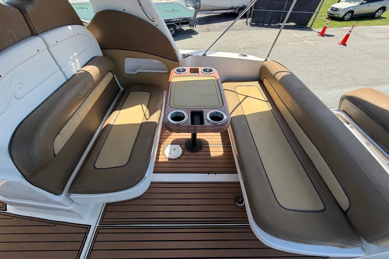 Slide: The Image of Interior seating area of a 2006 Sea Ray 300 Sundancer boat with table and cup holders. - 19