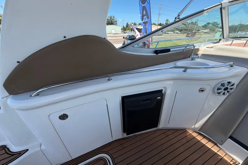 Slide: The Image of 2006 Sea Ray 300 Sundancer cockpit with sink, speaker, and storage compartments. - 23
