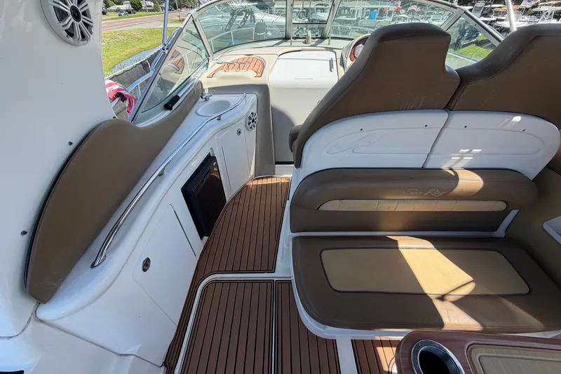 Slide: The Image of 2006 Sea Ray 300 Sundancer interior with brown seating and wood flooring. - 22