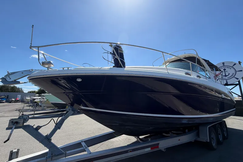Slide: The Image of 2006 Sea Ray 300 Sundancer boat on trailer under clear blue sky. - 11
