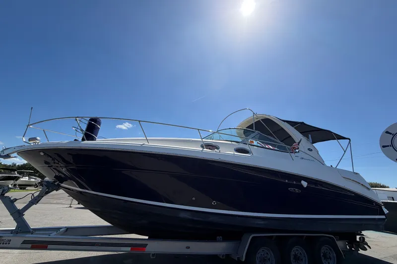 Slide: The Image of 2006 Sea Ray 300 Sundancer boat on trailer under clear blue sky. - 10