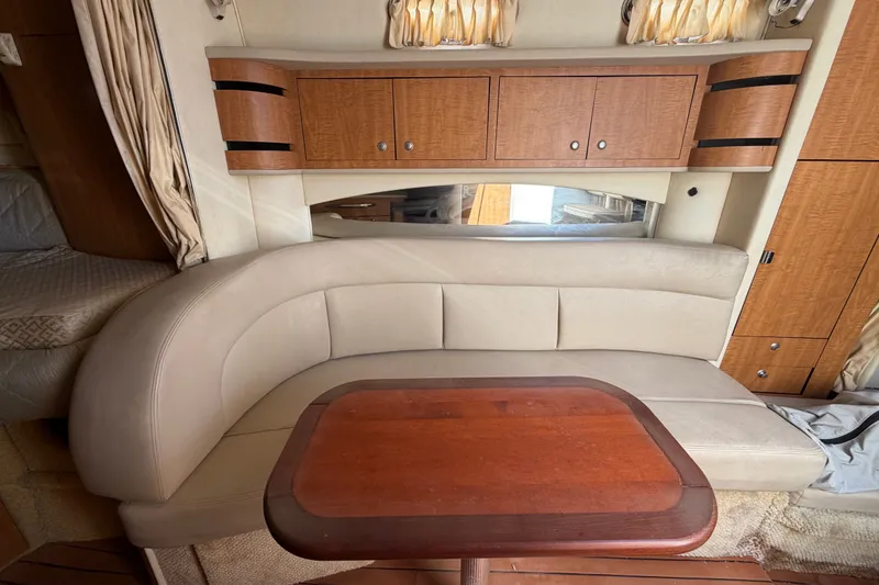 Slide: The Image of Interior of 2006 Sea Ray 300 Sundancer with beige seating and wooden cabinetry. - 86