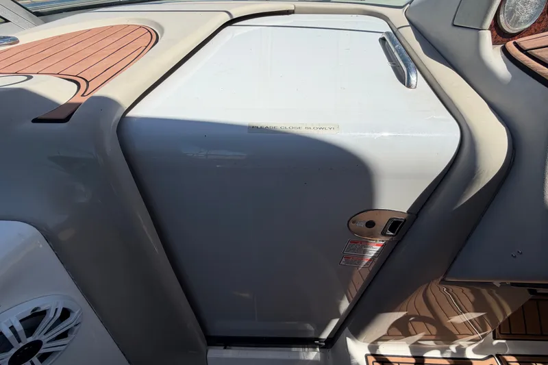 Slide: The Image of 2006 Sea Ray 300 Sundancer boat interior with wood accents and storage compartment. - 54
